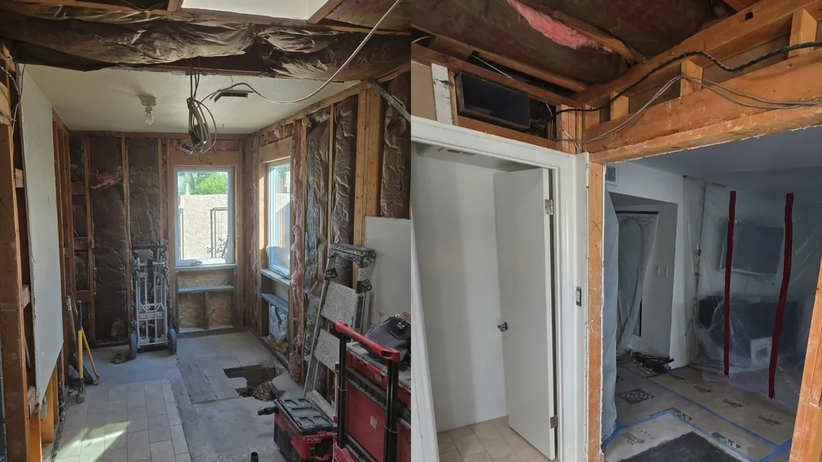 Gutted room with open wall framing, tools on the floor and bright windows at the far end