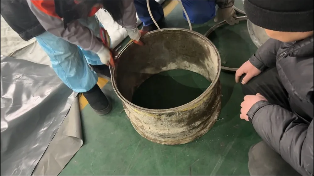 Group of people around a bucket of green resin on a plastic tarp